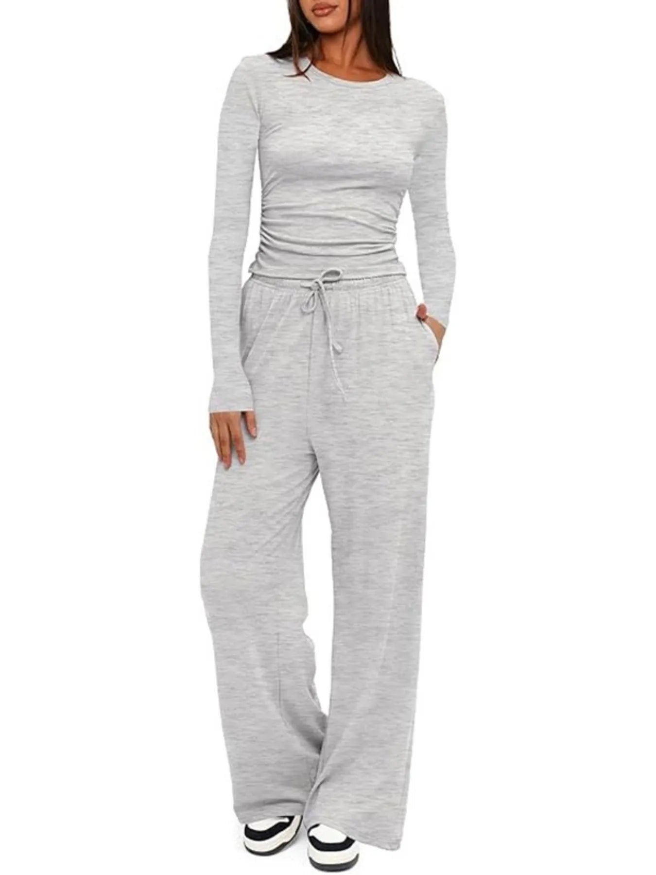 Woman wearing a gray long-sleeve top and wide-leg pants on a white background