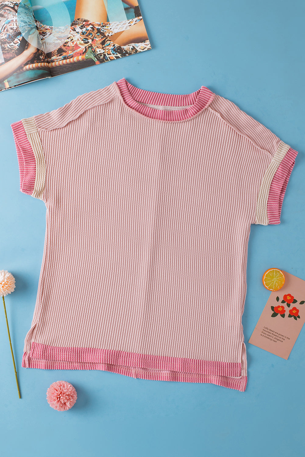 Pink and white striped shirt on a blue background with decorative items around