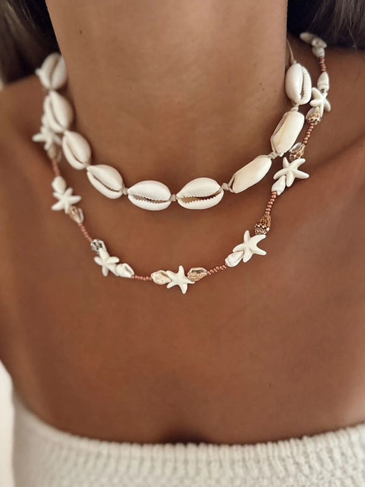 Necklace with shell and starfish designs on a person's neck