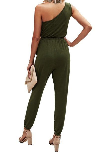 Woman wearing a green one-shoulder jumpsuit on a white background