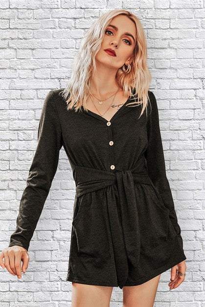 Woman wearing a black dress with a white brick wall background