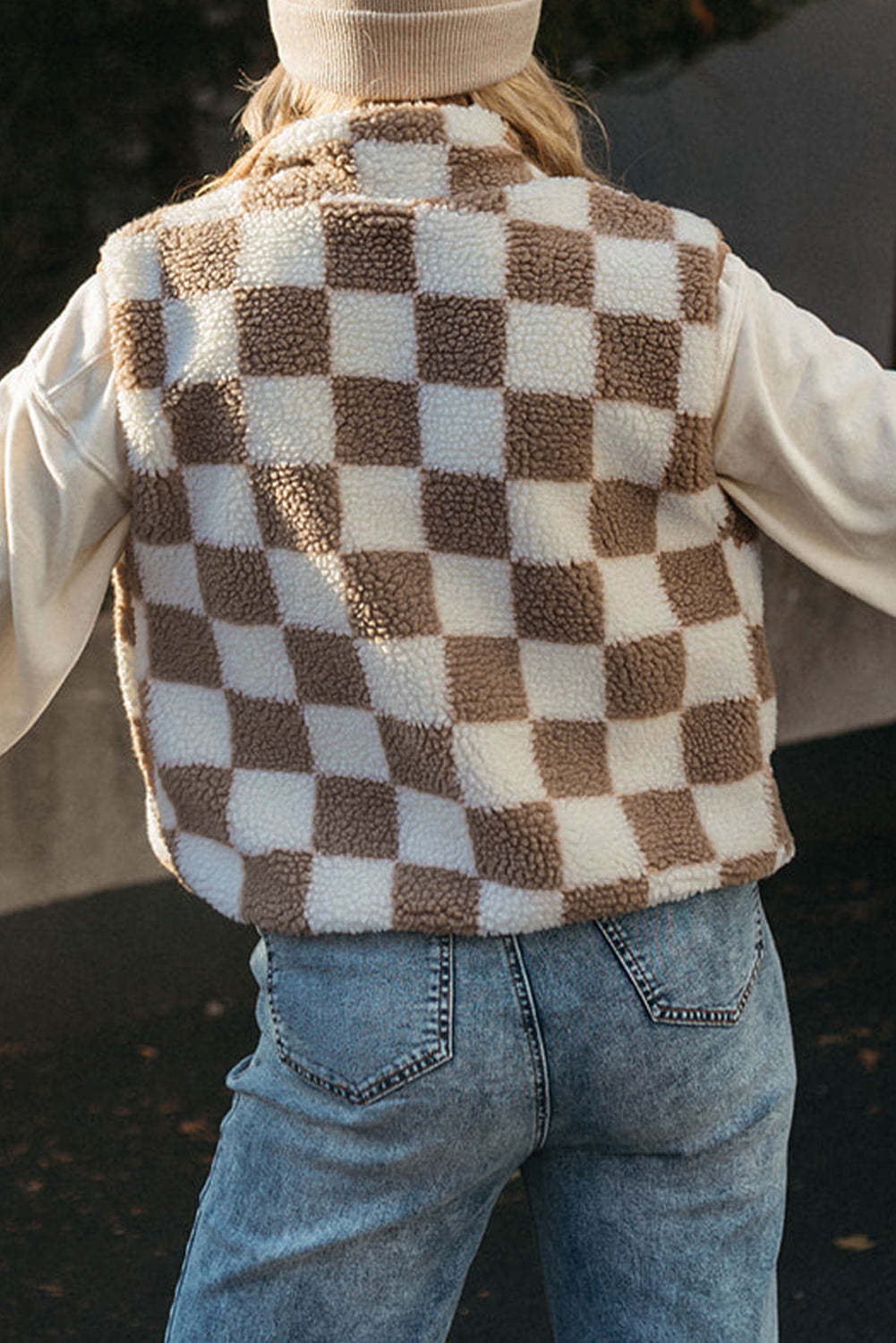 Person wearing a checkered vest with a blurred background
