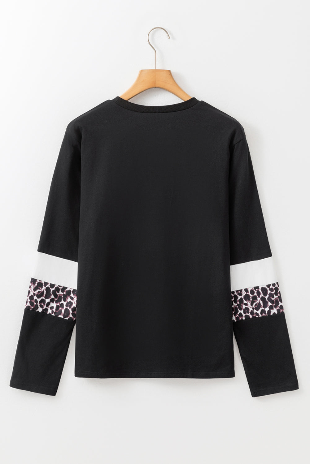 Black long-sleeve top with leopard print cuffs on a white background