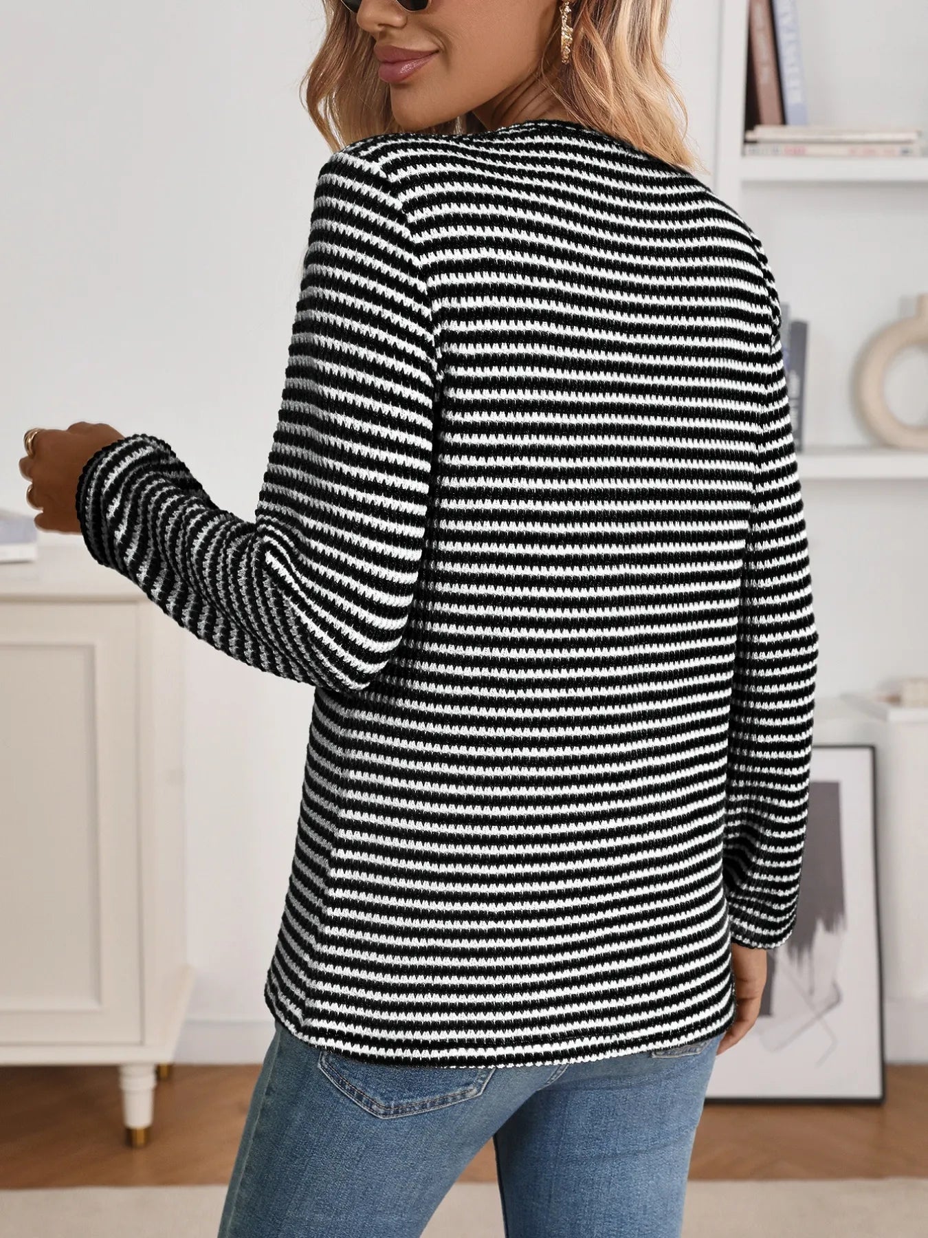 person wearing a long sleeve striped blouse