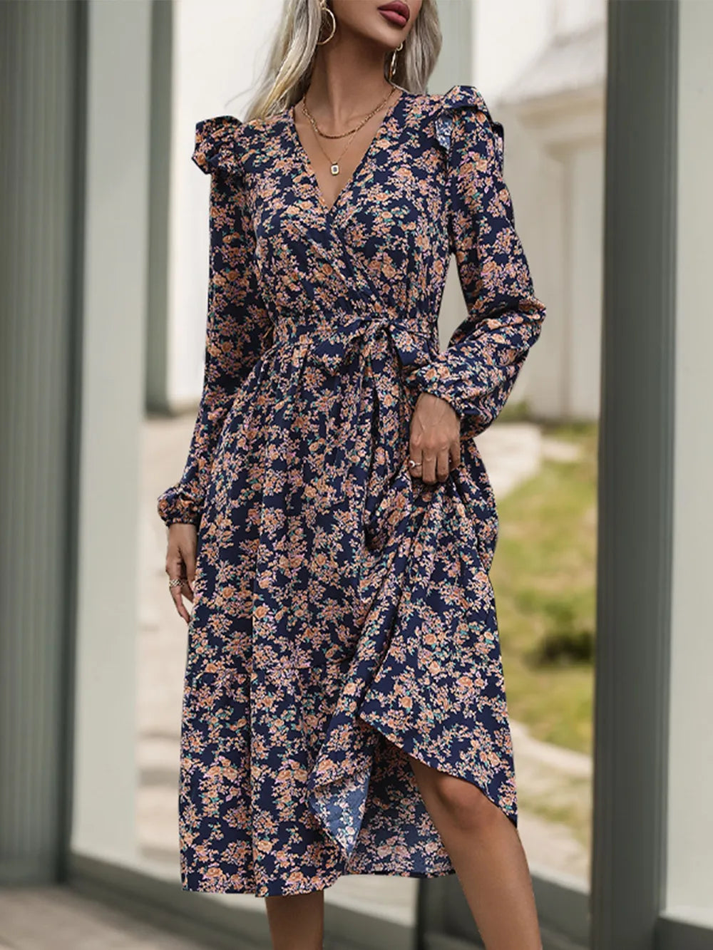 Woman wearing a floral dress standing outdoors.