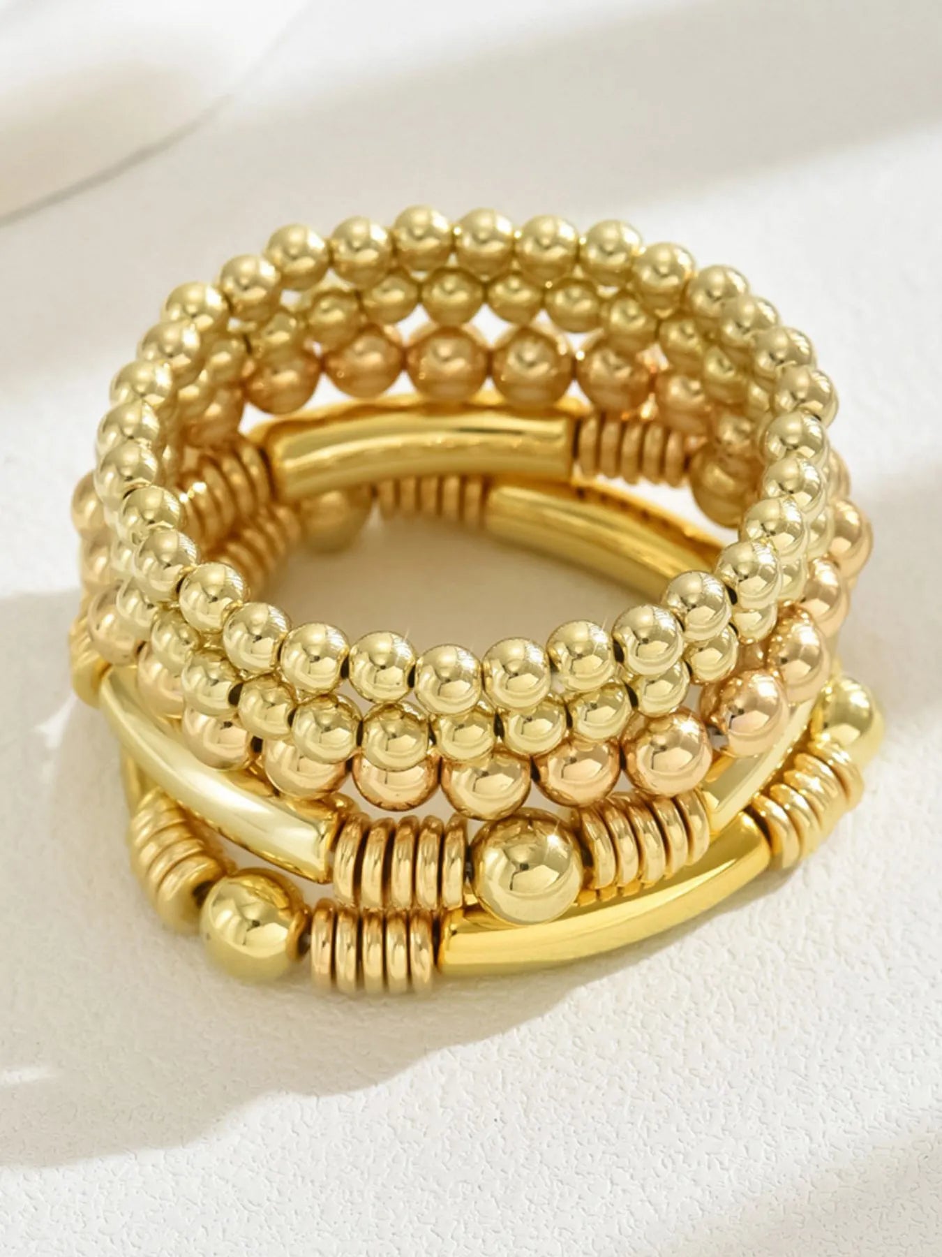 Gold beaded bracelet on a white background