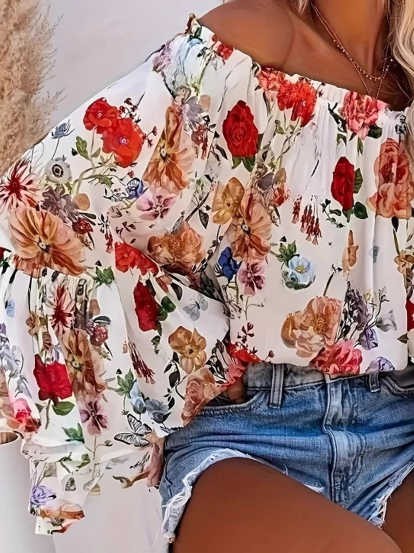 Floral off-shoulder top worn by a person with a blurred background