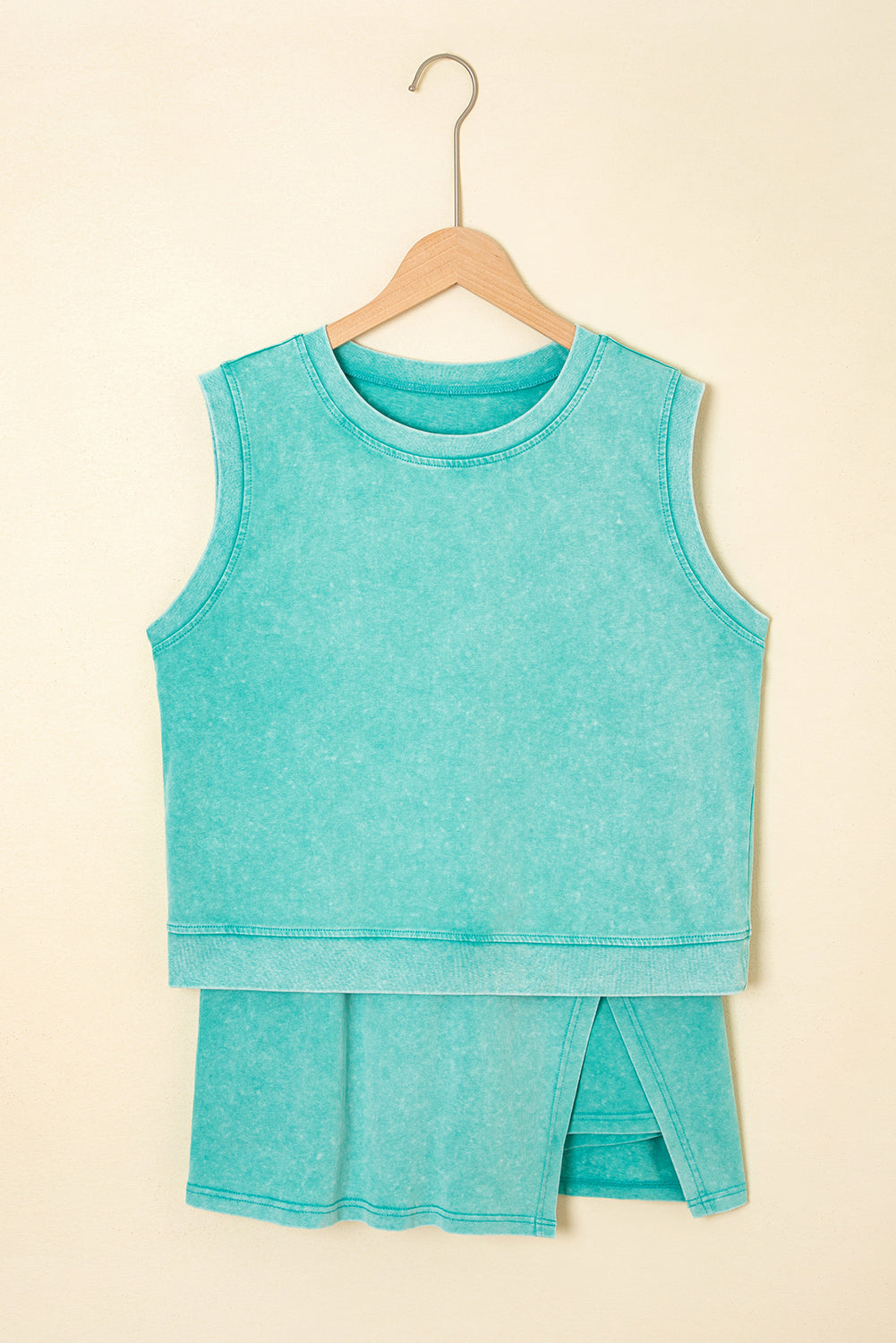 Turquoise sleeveless top and shorts set on a beige background