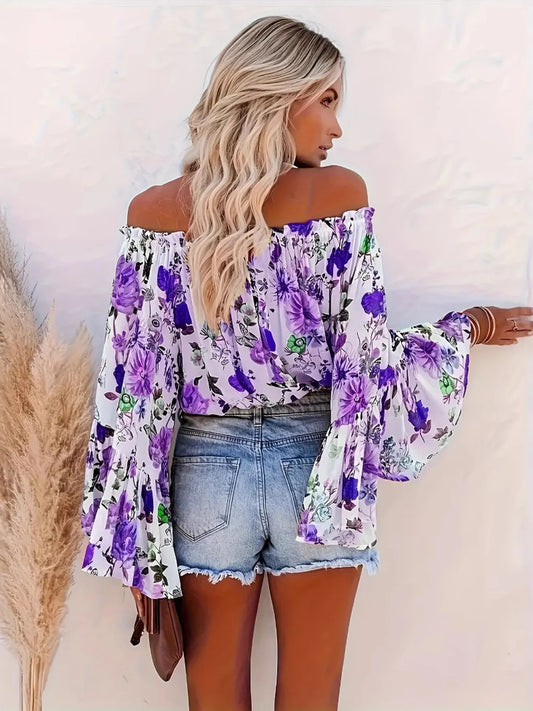 Woman wearing a floral off-shoulder top with purple flowers, standing against a white background.