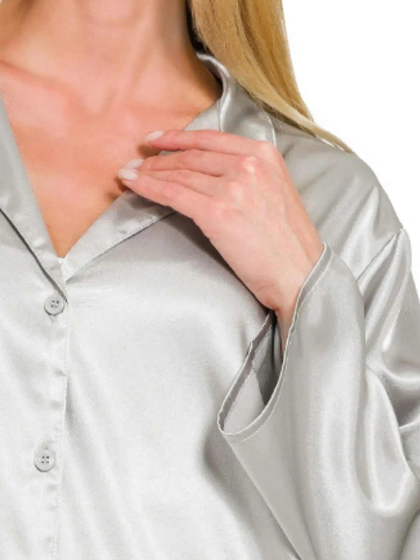 Close-up of a person wearing a satin shirt with a blurred background