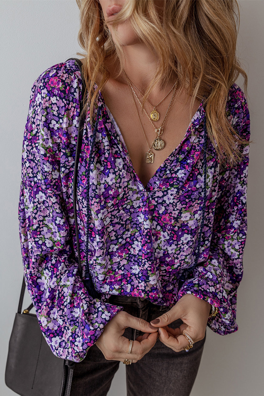 Woman wearing a purple floral blouse with a neutral background