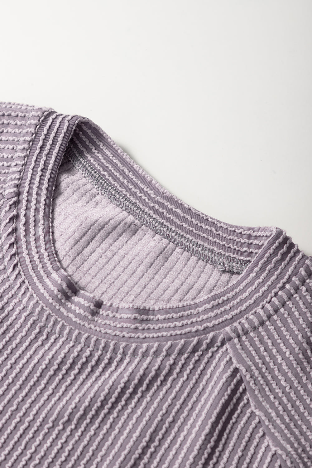 Close-up of a textured purple garment with a white background