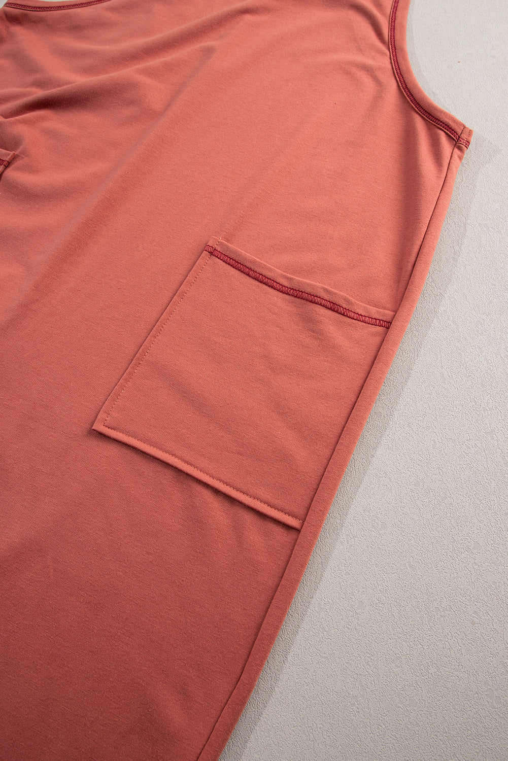 Close-up of a pink tank top with a pocket on a light gray background