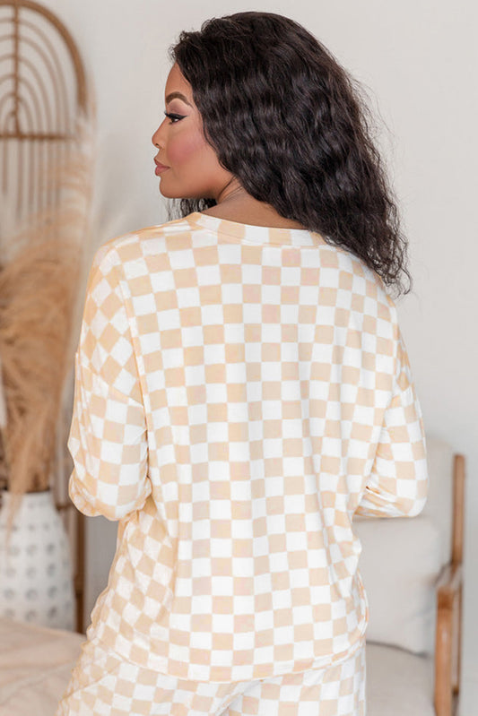 Woman wearing a beige and white checkered dress in a minimal indoor setting