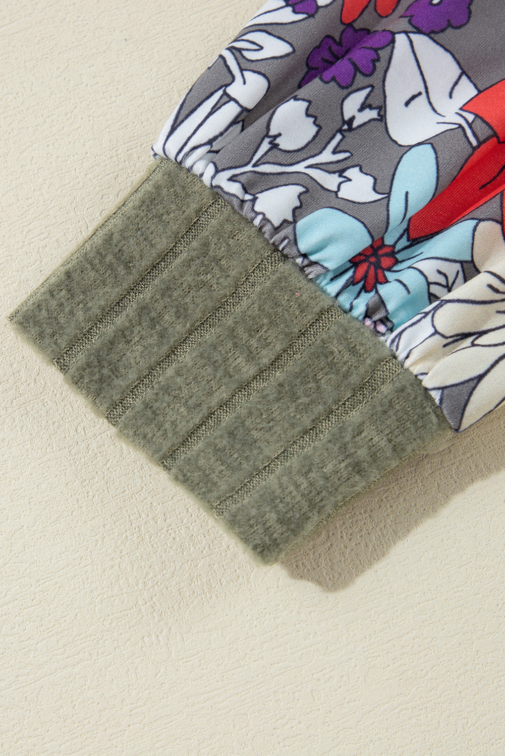 Gray fabric swatch on a floral-patterned fabric background