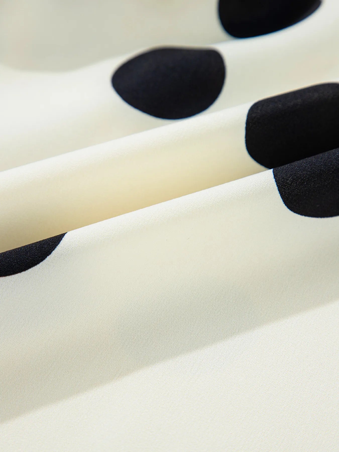 Close-up of a white surface with black polka dots