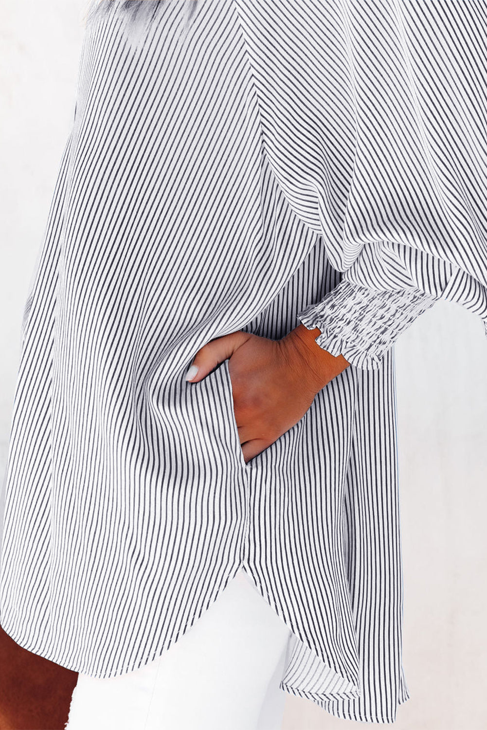 Close-up of a person wearing a black and white striped shirt with a white background