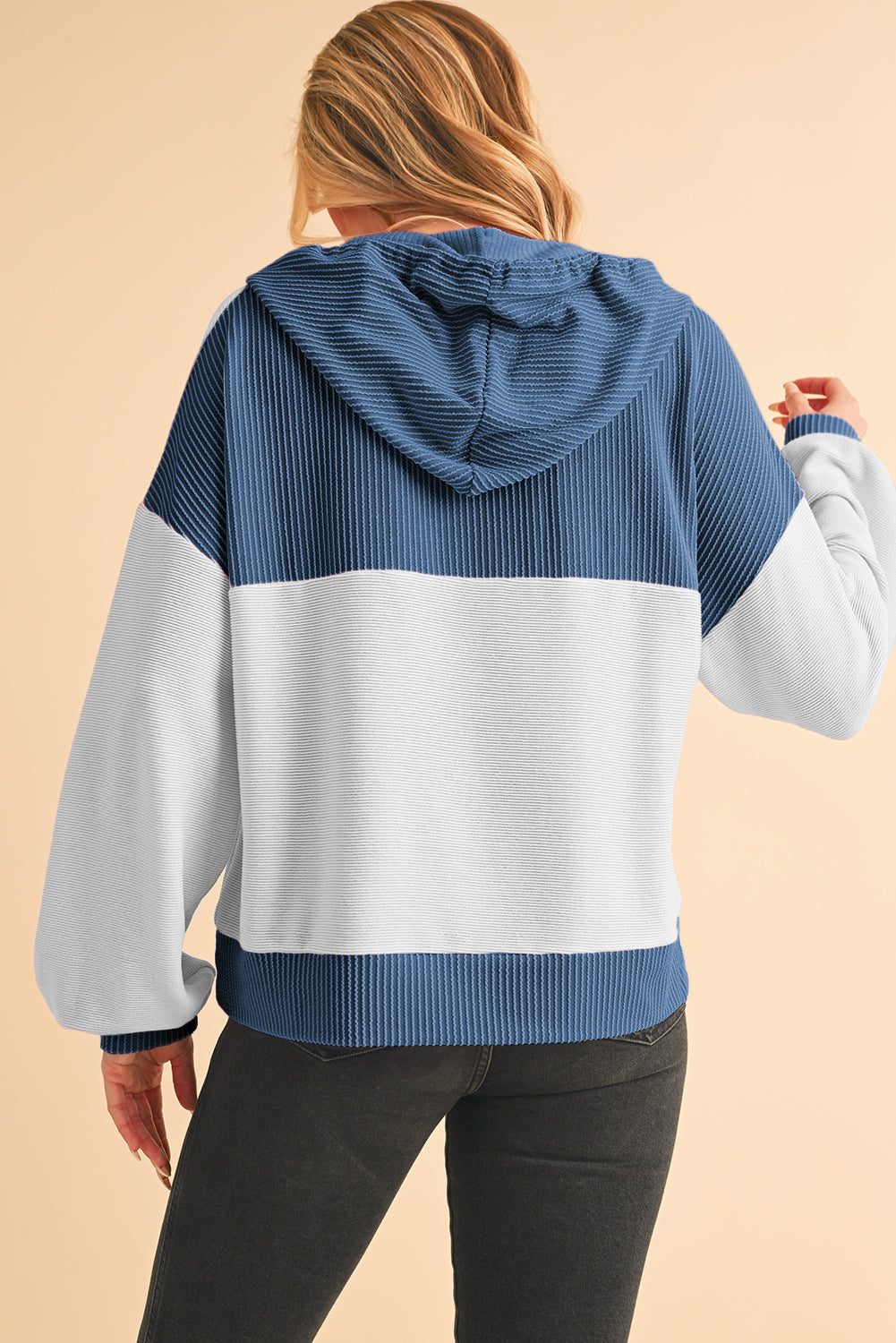 Person wearing a blue and white striped hoodie on a beige background