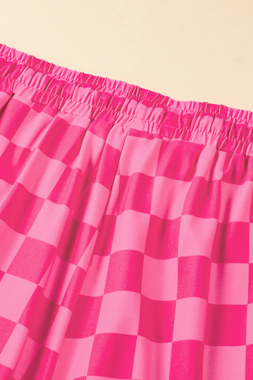 Close-up of a pink checkered skirt on a beige background