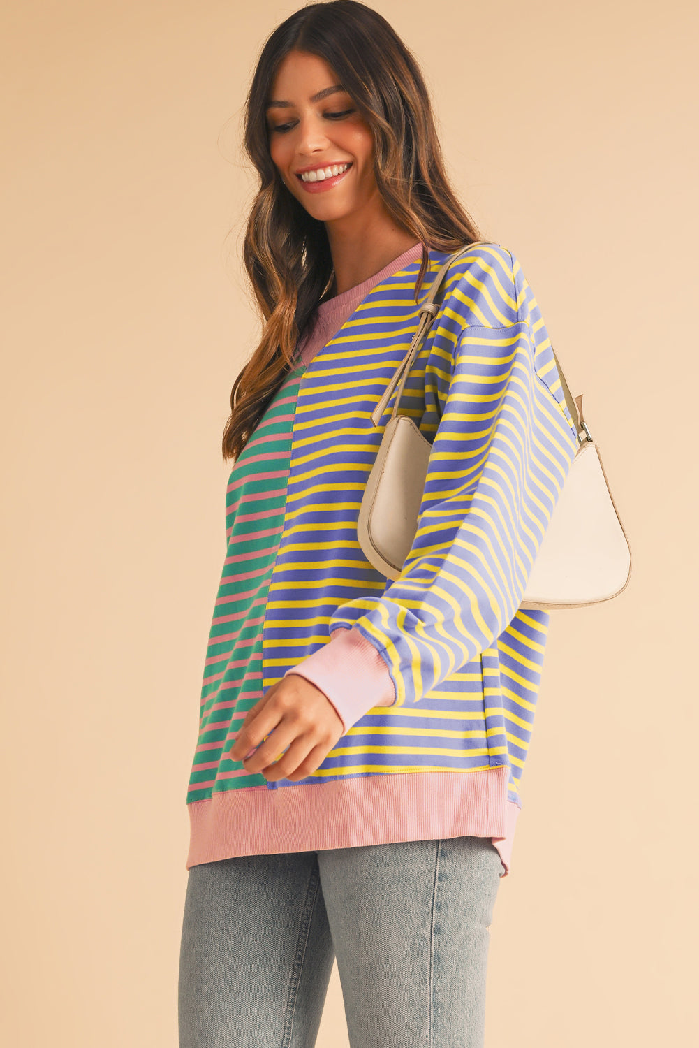 Woman wearing a colorful striped shirt with a beige background