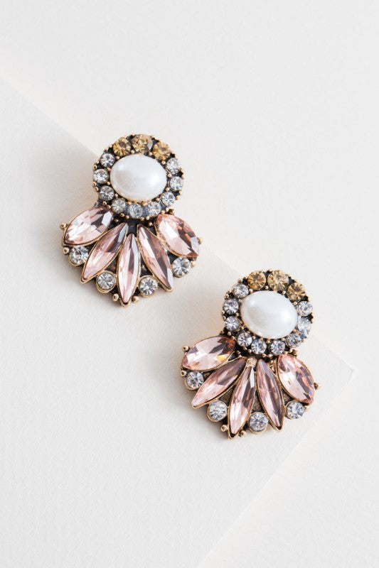 Pair of earrings with pink and white stones on a light background