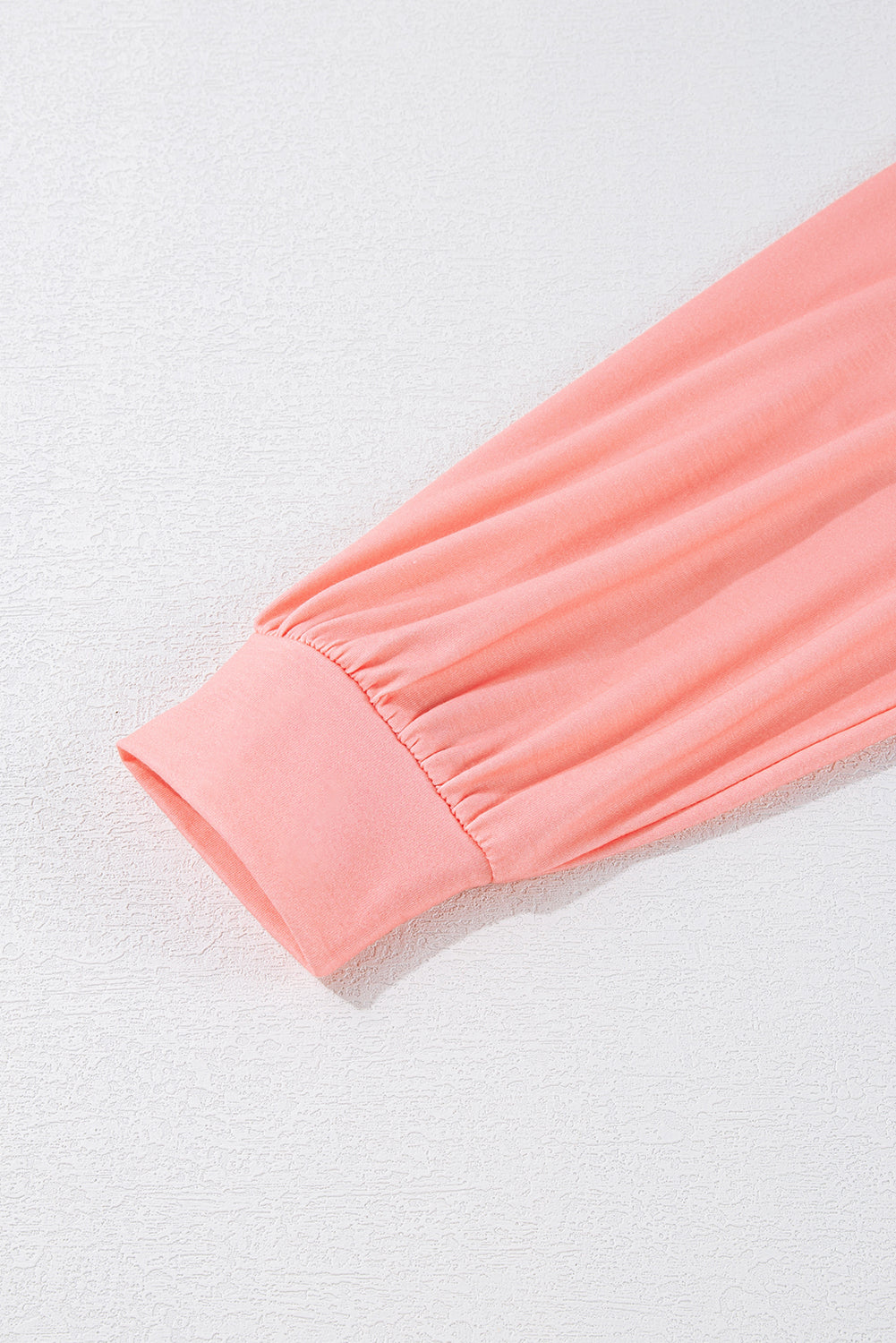 Close-up of a pink fabric edge on a light gray background