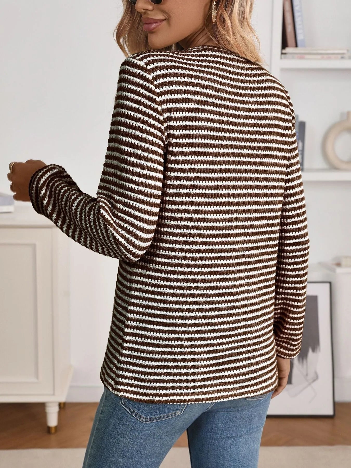 person wearing a long sleeve striped blouse