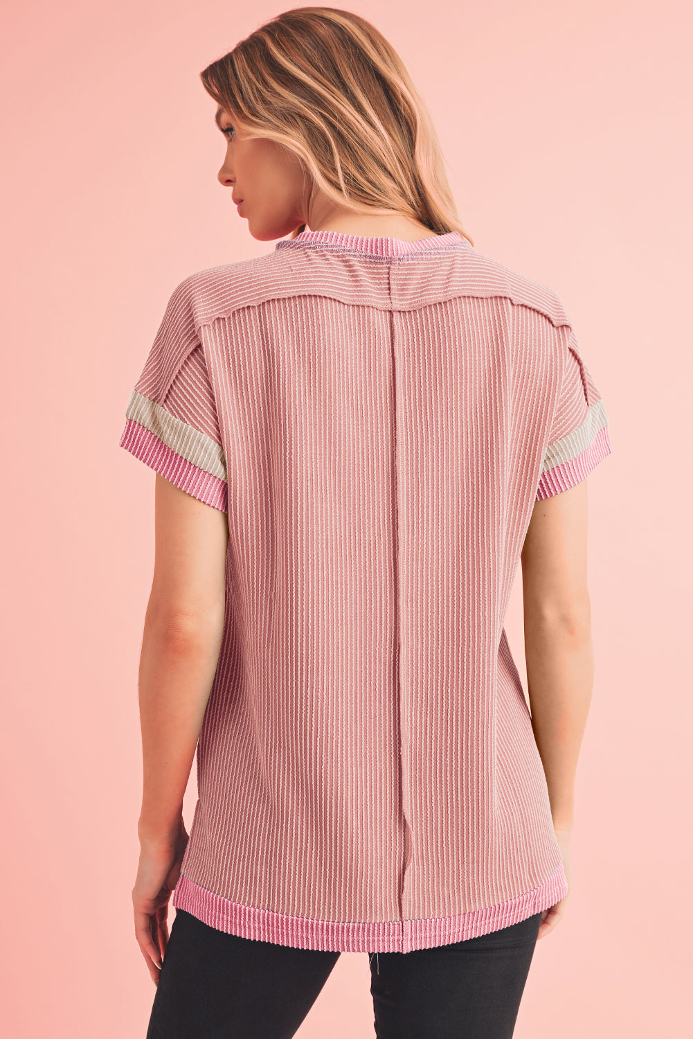Woman wearing a pink and white striped shirt on a pink background