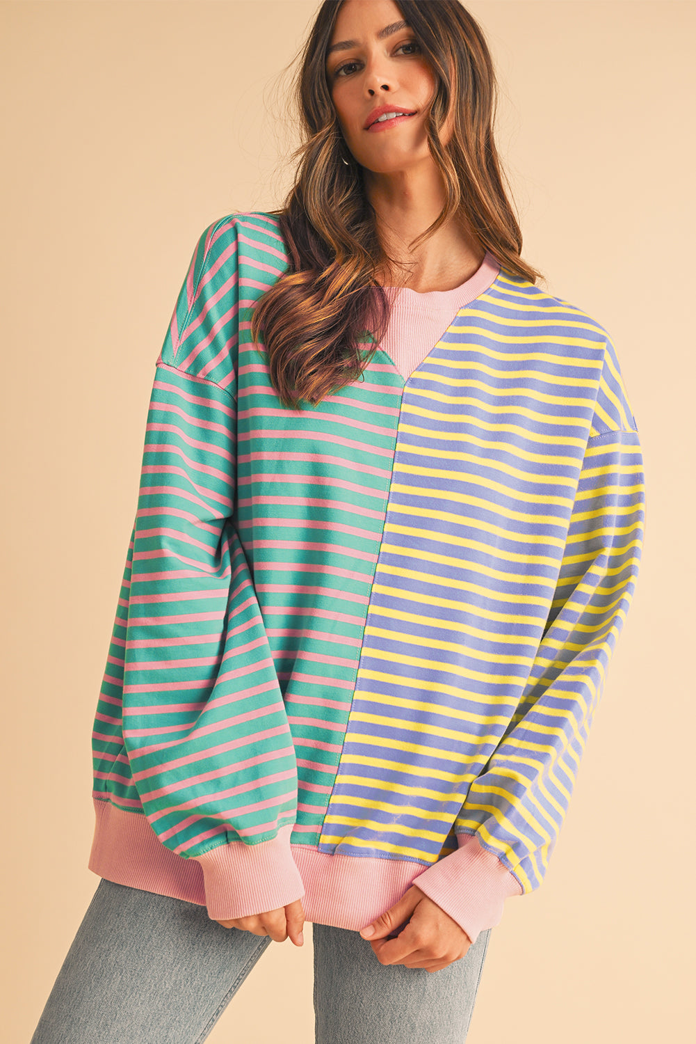 Woman wearing a colorful striped sweater on a beige background