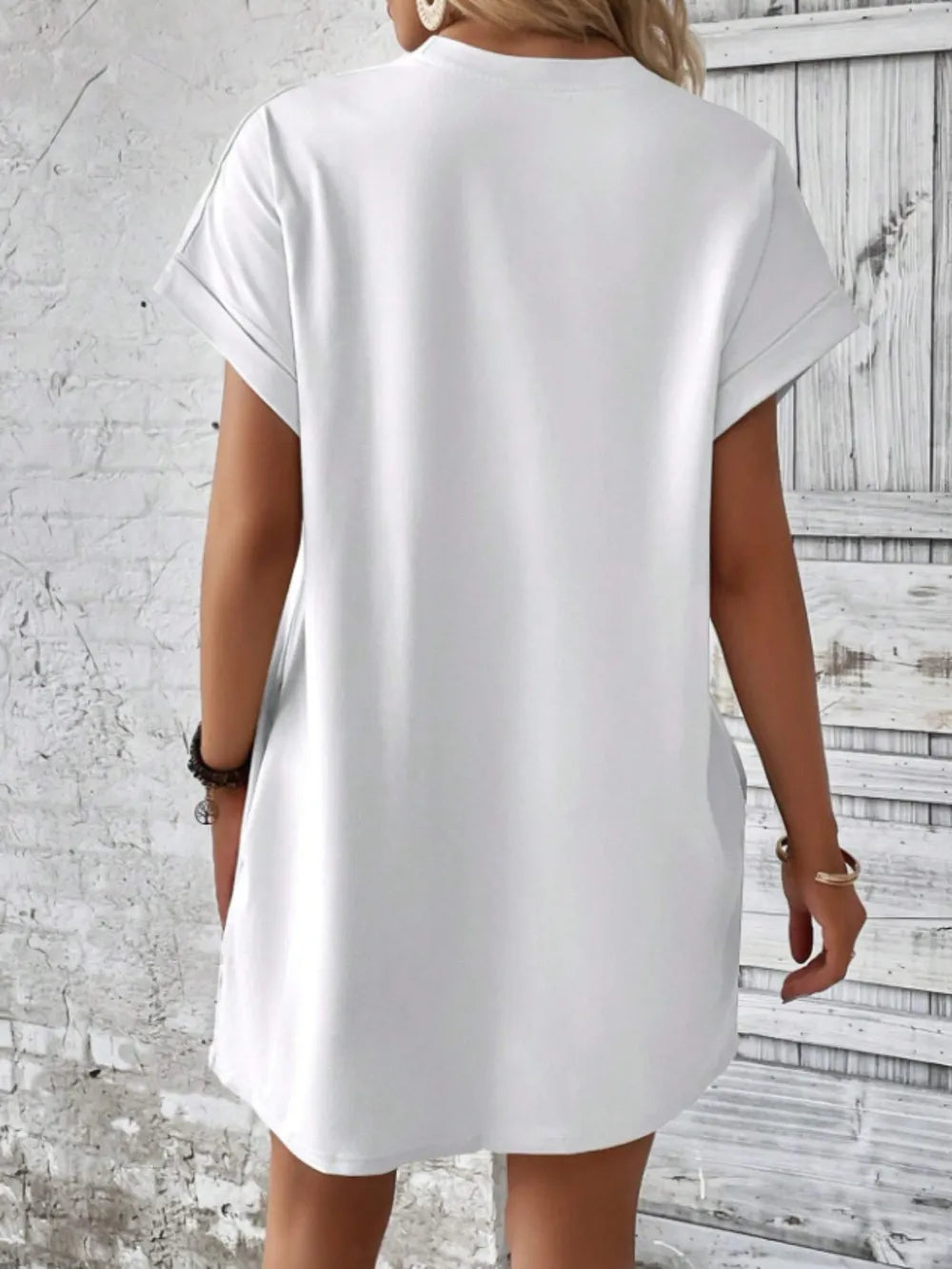 Person wearing a white dress against a textured wall background