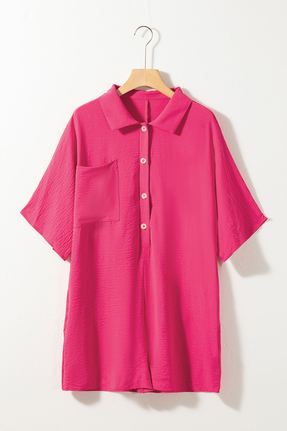 Pink shirt on a hanger against a white background
