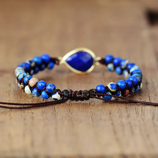 Blue beaded bracelet with a gold accent on a wooden surface