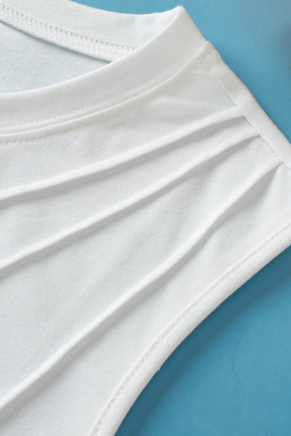 Close-up of a white fabric garment on a blue background
