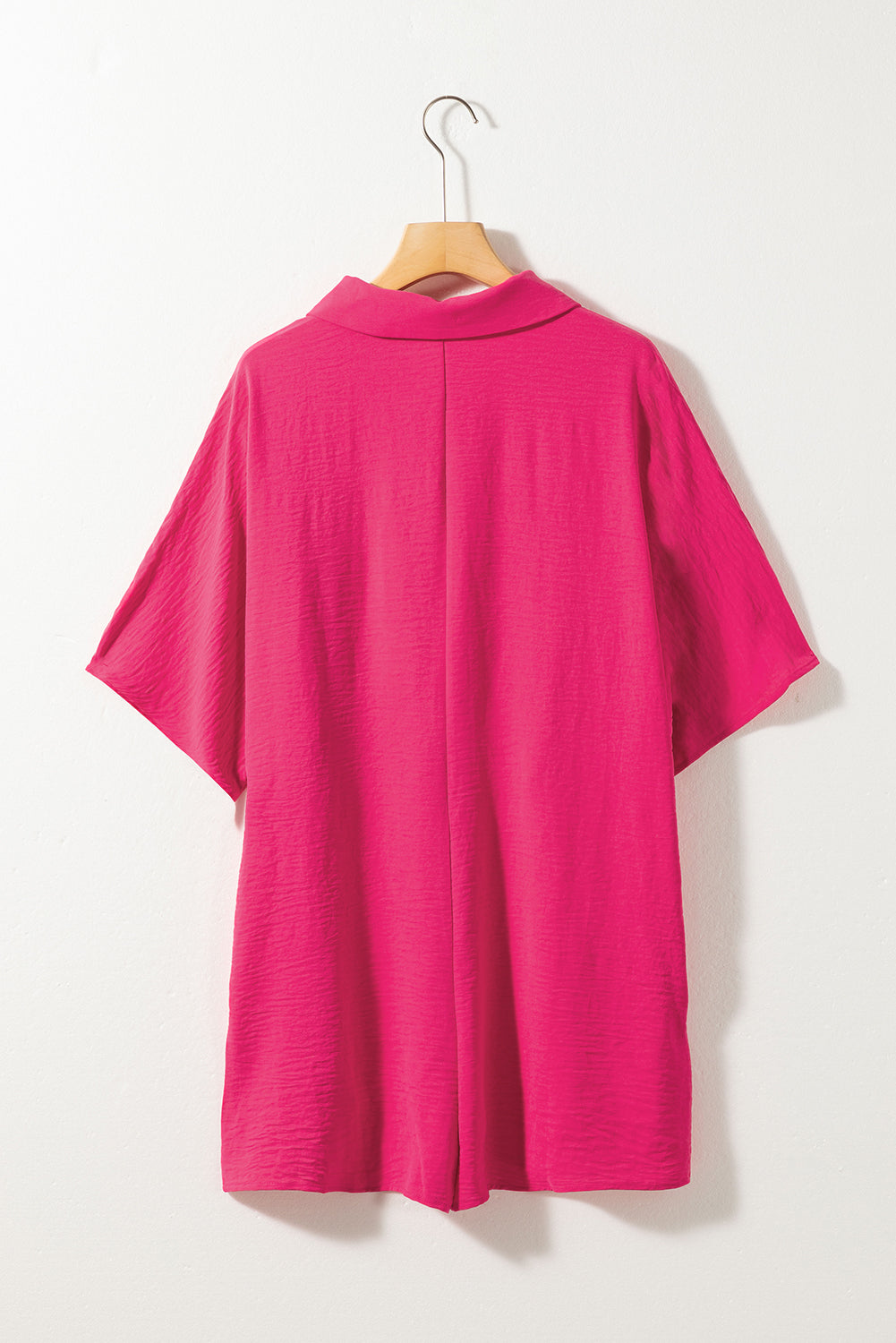Pink dress on a hanger against a white background