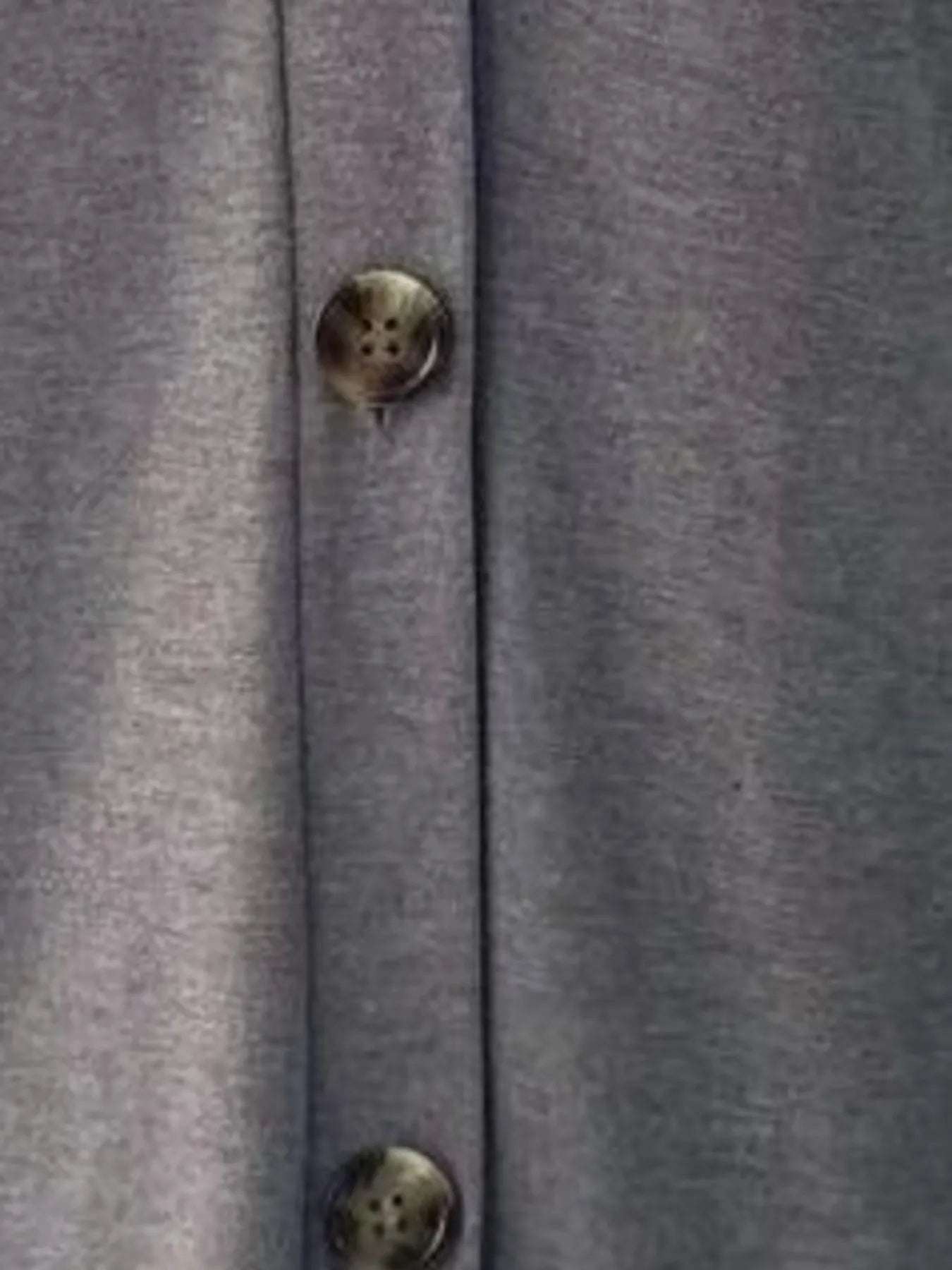 Close-up of a gray textured fabric with a button