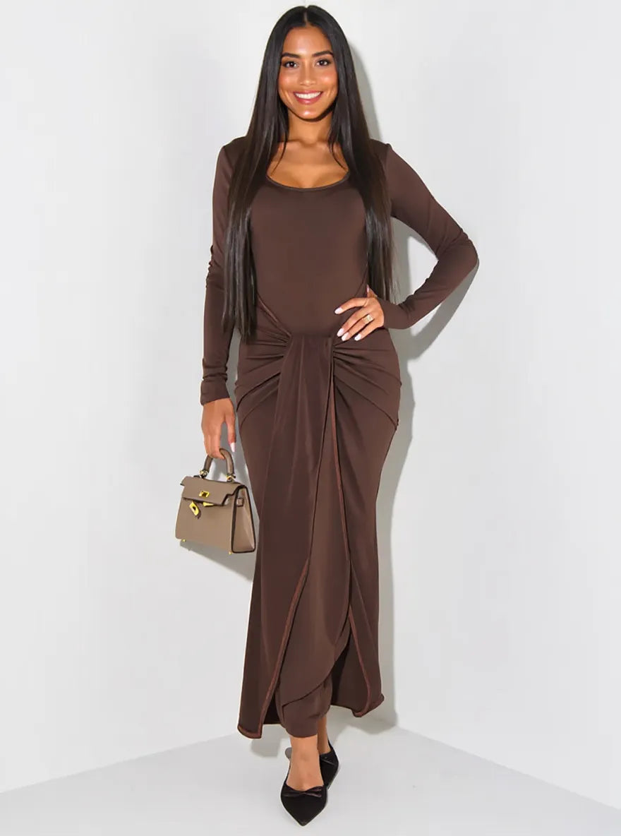 Woman wearing a brown dress with a matching cardigan against a white background