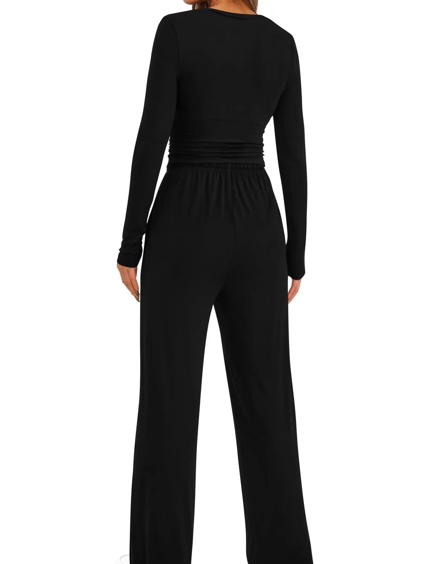 Black jumpsuit worn by a person on a white background