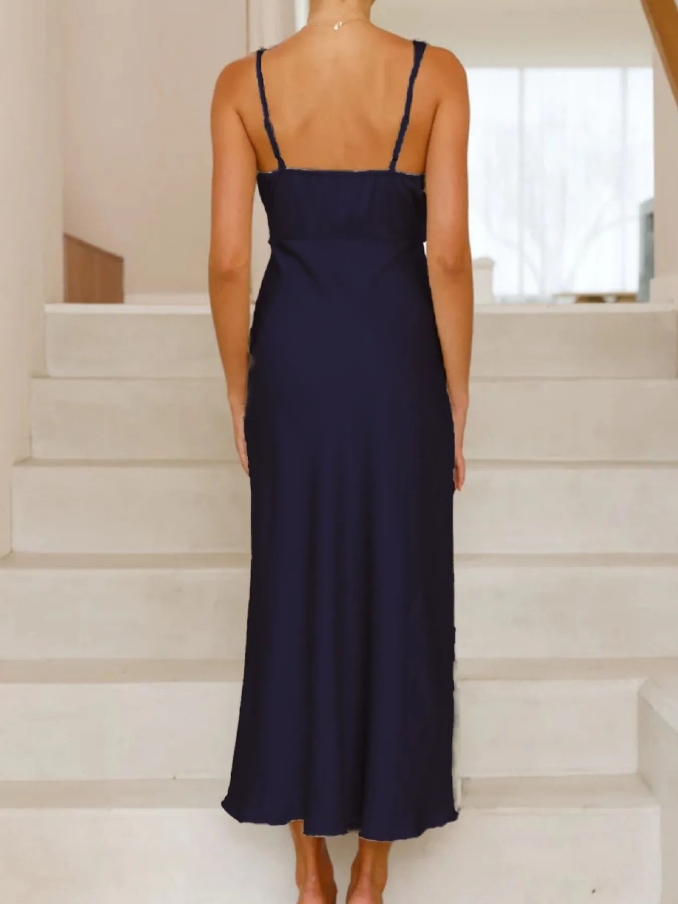 Navy blue dress worn by a person standing on white steps.