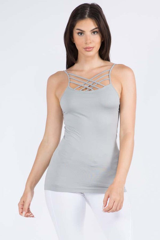 Woman wearing a gray tank top with criss-cross straps on a white background