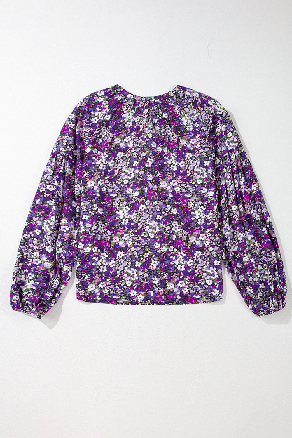Floral patterned blouse with purple and white flowers on a white background