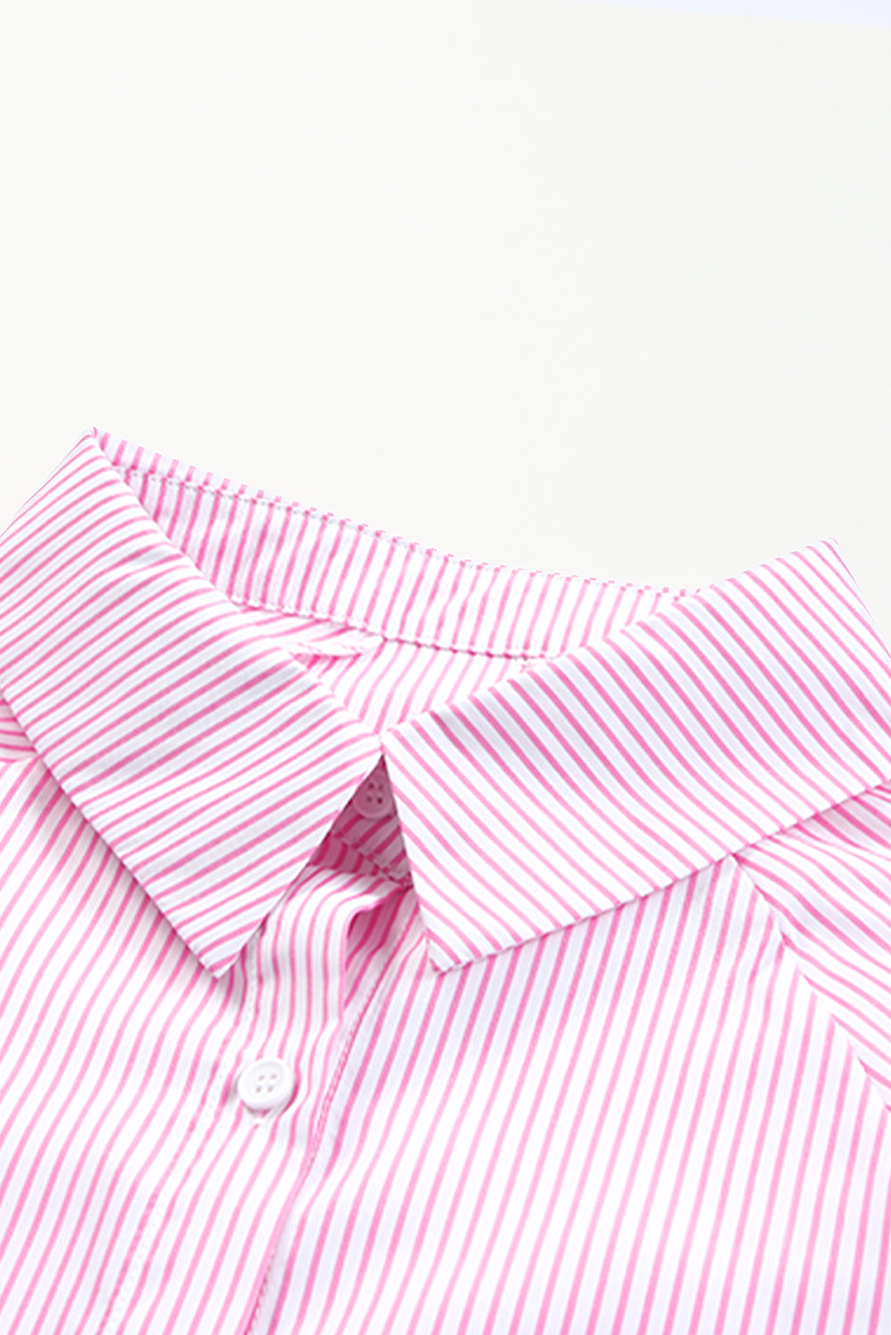 Close-up of a pink and white striped shirt collar on a white background