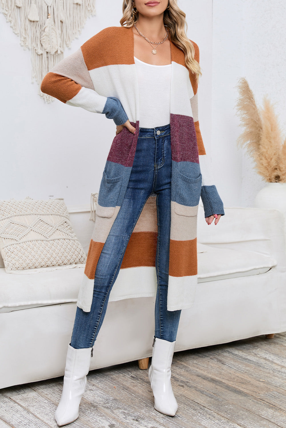 Woman wearing a colorful striped sweater and blue jeans in a living room setting.