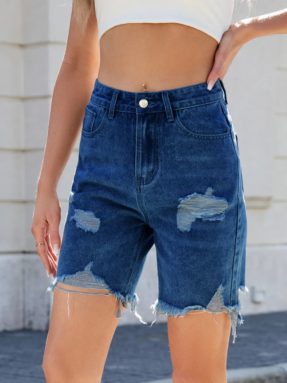 Person wearing blue denim shorts with a blurred background