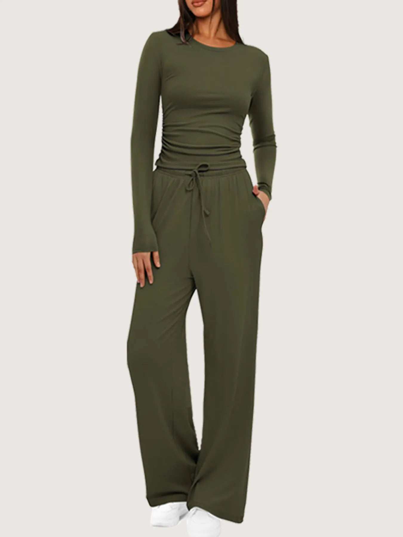 Green jumpsuit worn by a model on a white background