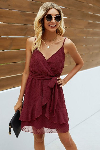 Woman wearing a burgundy dress with a wooden background