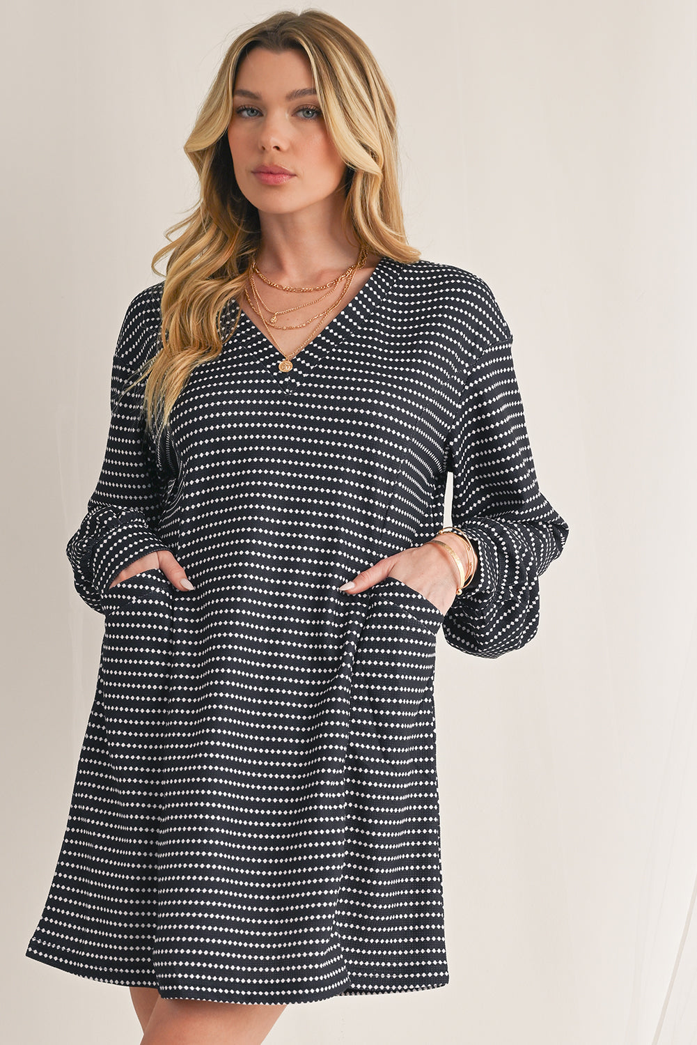 Woman wearing a black and white patterned dress against a plain background