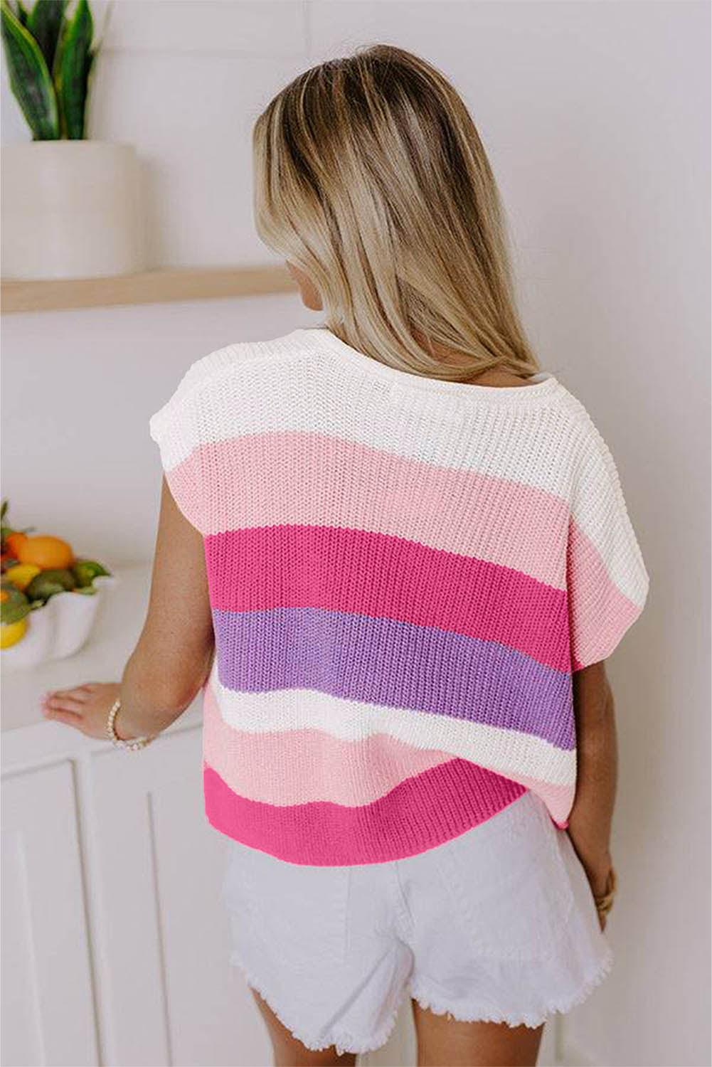 Woman wearing a colorful striped sweater in a kitchen setting