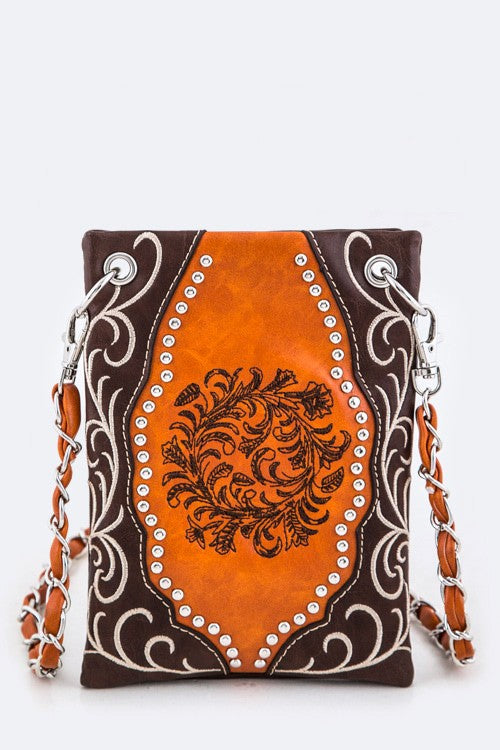 Brown and orange handbag with intricate designs on a white background