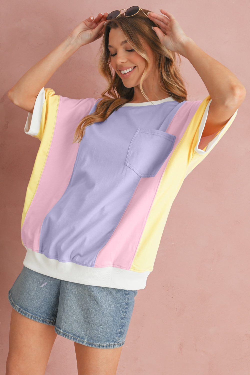 Woman wearing a colorful top with pastel shades on a pink background