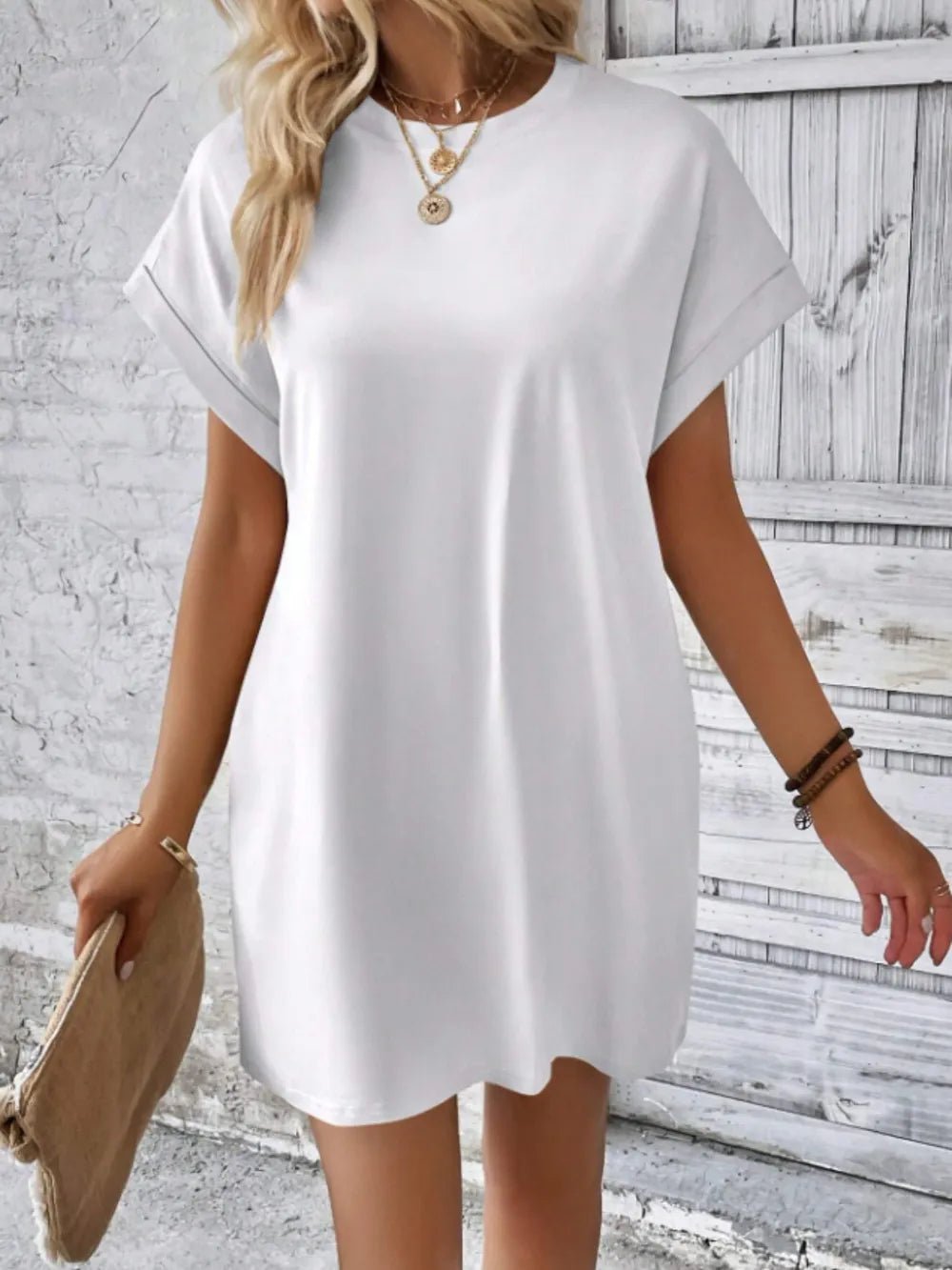 Woman wearing a white dress against a textured wall background